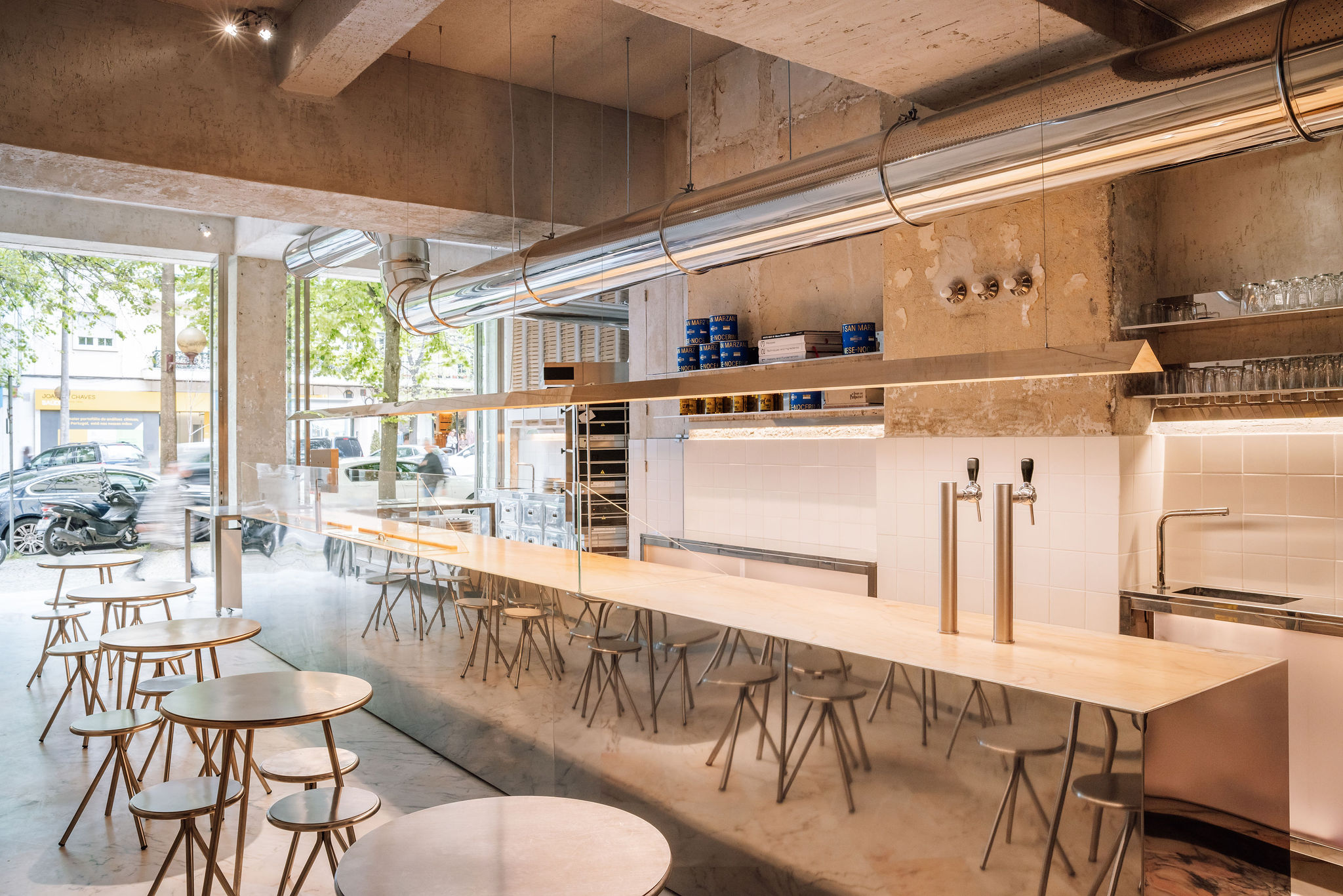 Lupita Alvalade by XXXI.studio with an open pizza-making area facing the street in Lisbon, Portugal