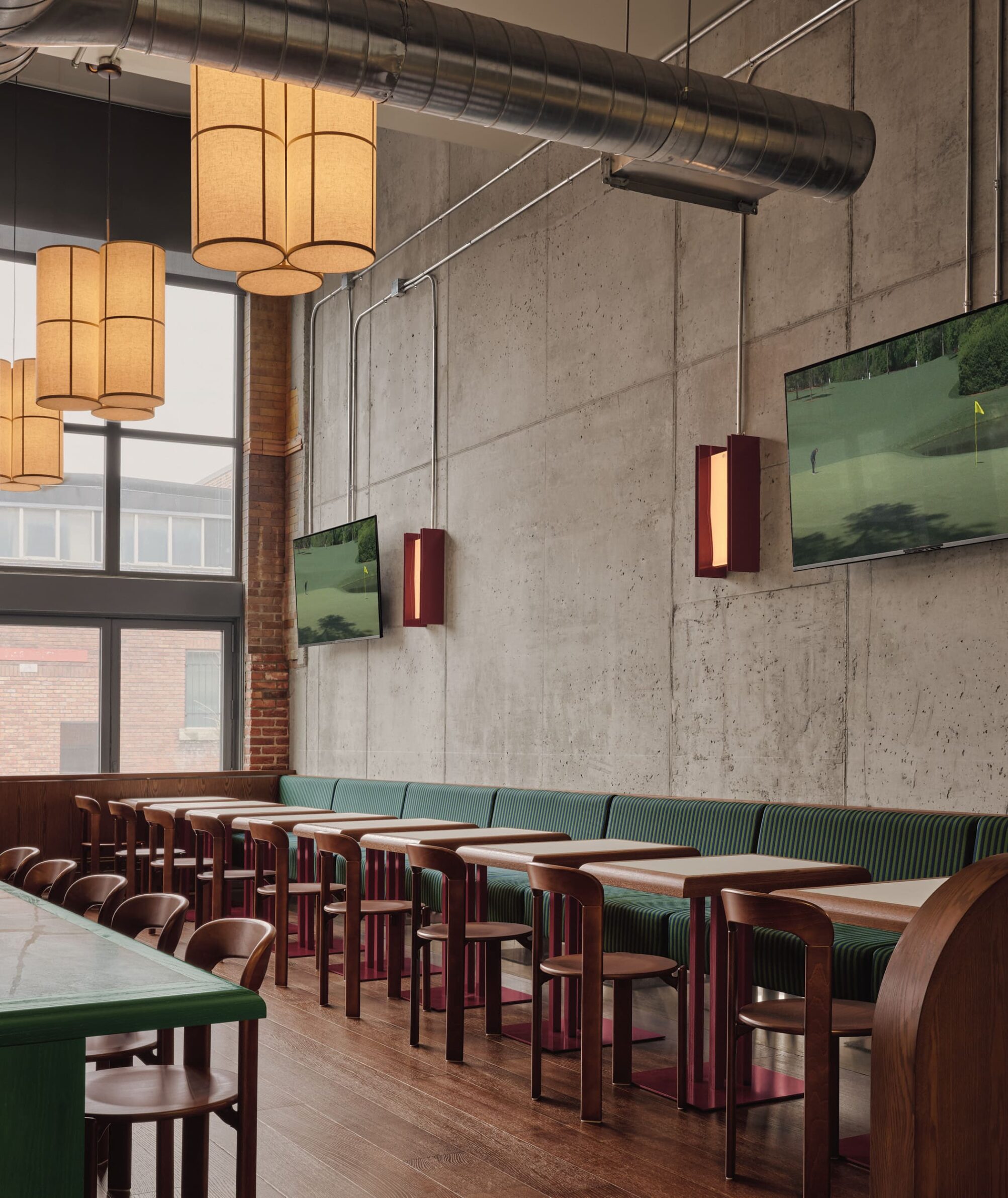 MUNI by IVY Studio inside Montreal’s historic Nordelec building, combining dining, bar and golf lounges
