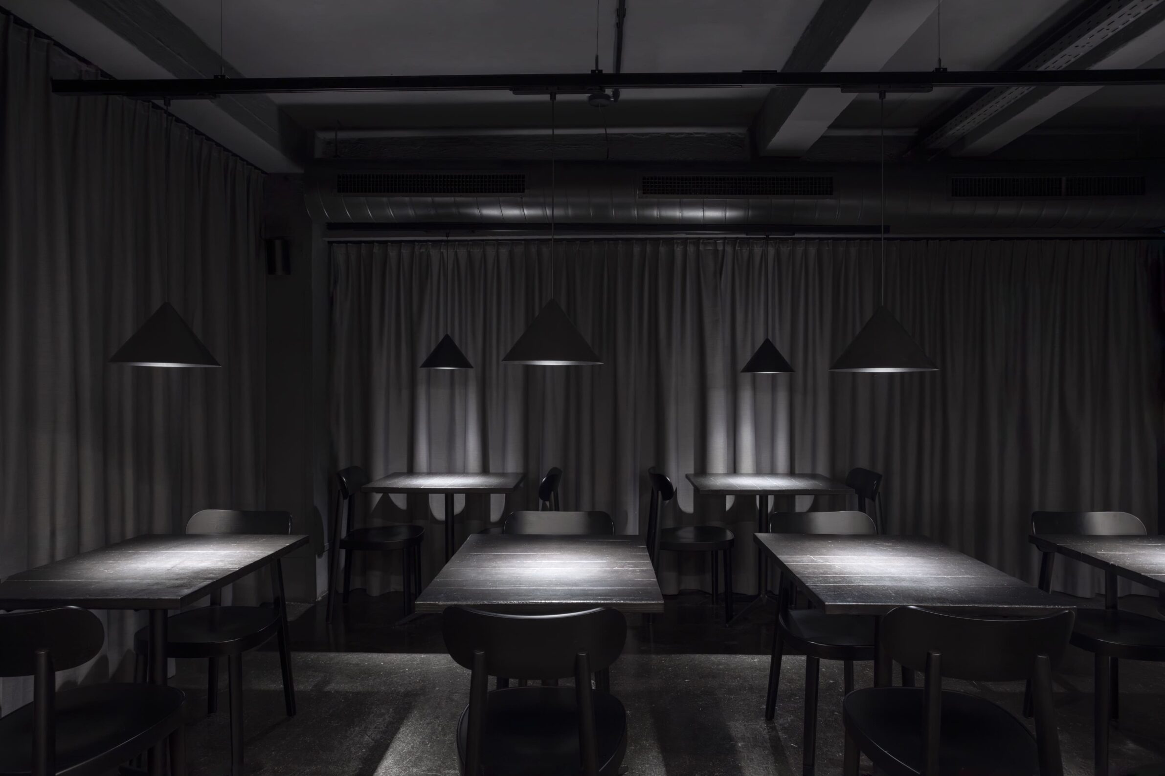 Pizzeria 22K by destilat with a dark interior and red brick bar in Linz, Austria